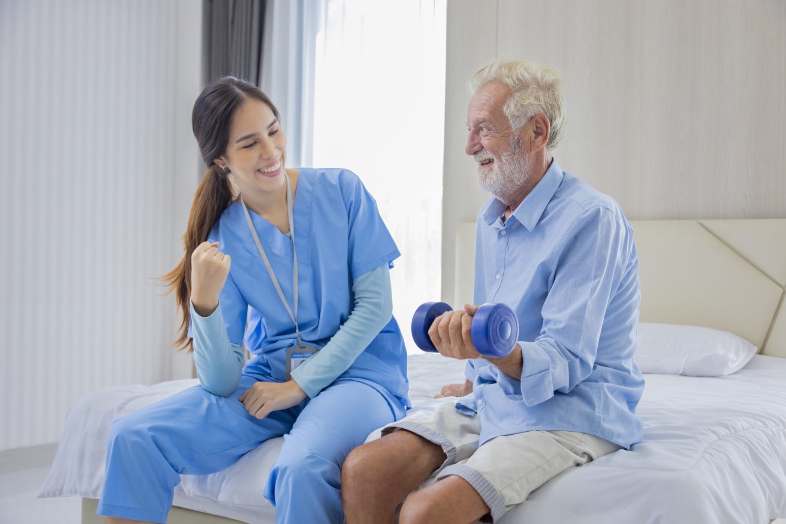 A nurse helping a man in bed with muscle-strengthening exercises.