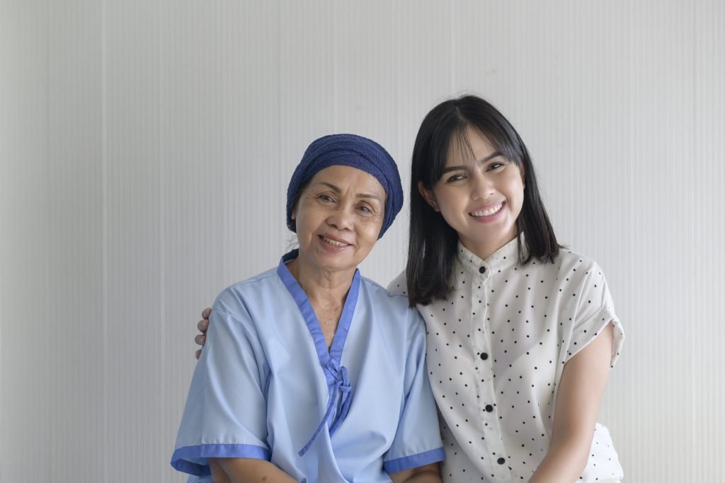 A woman wearing a head scarf sitting beside a younger family member in a hospital room.